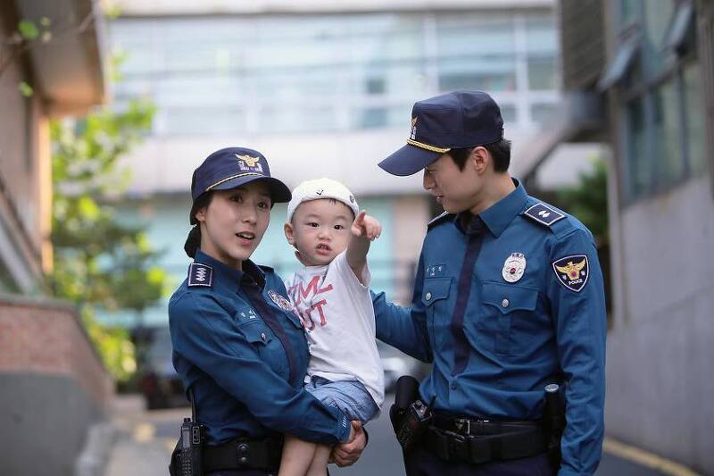 여자, 남자 경찰관이 아이를 돌보는 모습